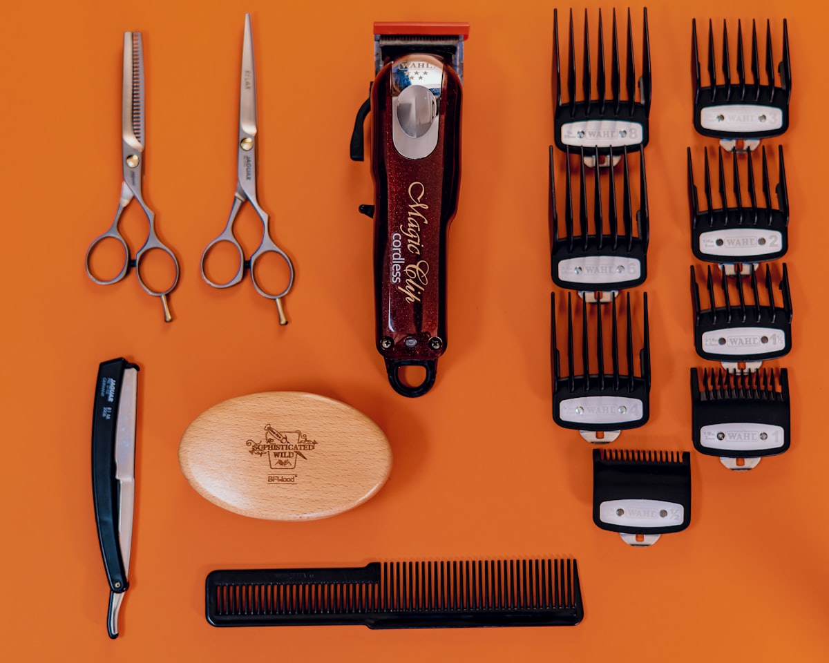 A barber's clippers, scissors and guards laid out